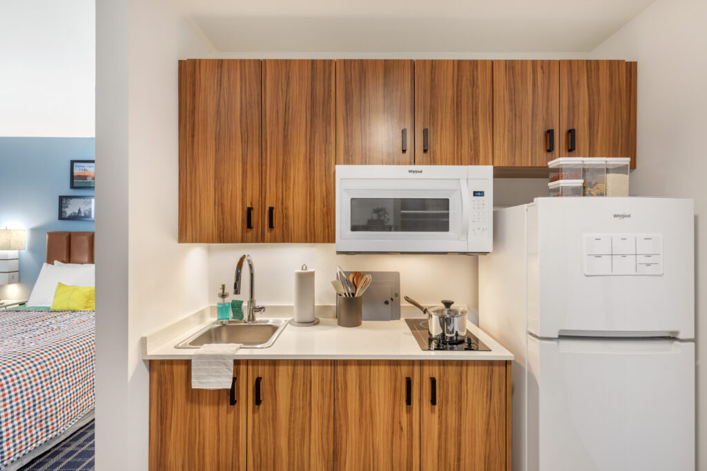 Kitchen amenities and surface area within suite, equipped with refrigerator and microwave.
