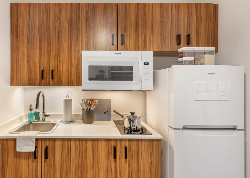 Kitchen amenities and surface area within suite, equipped with refrigerator and microwave.