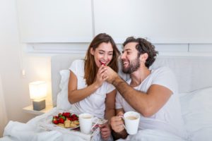 A couple having breakfast in bed for Valentine's Day 