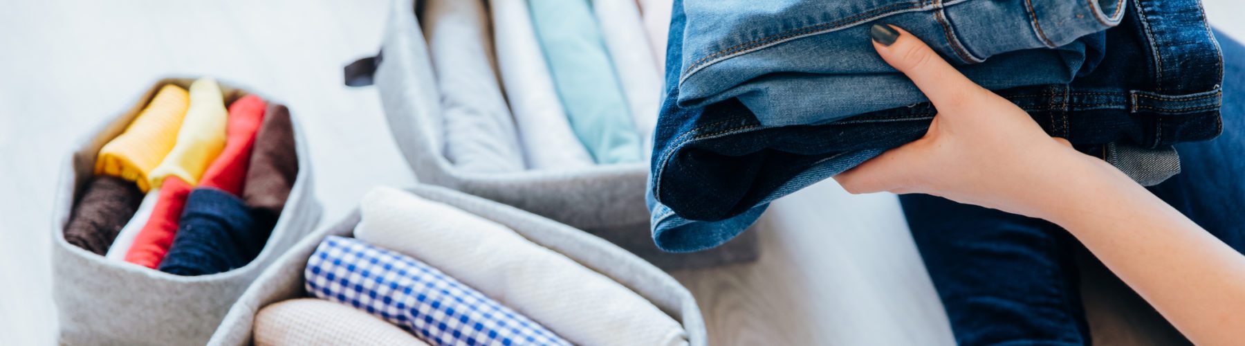 a person organizing and sorting their clothes into containers