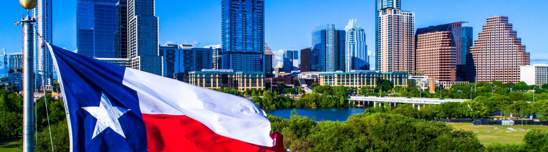 Texas Flag waving above Austin Skyline